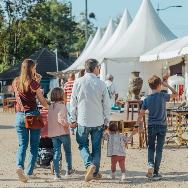 Famille avec les deux parents et les trois enfants marchant de dos à la foire de Chatou