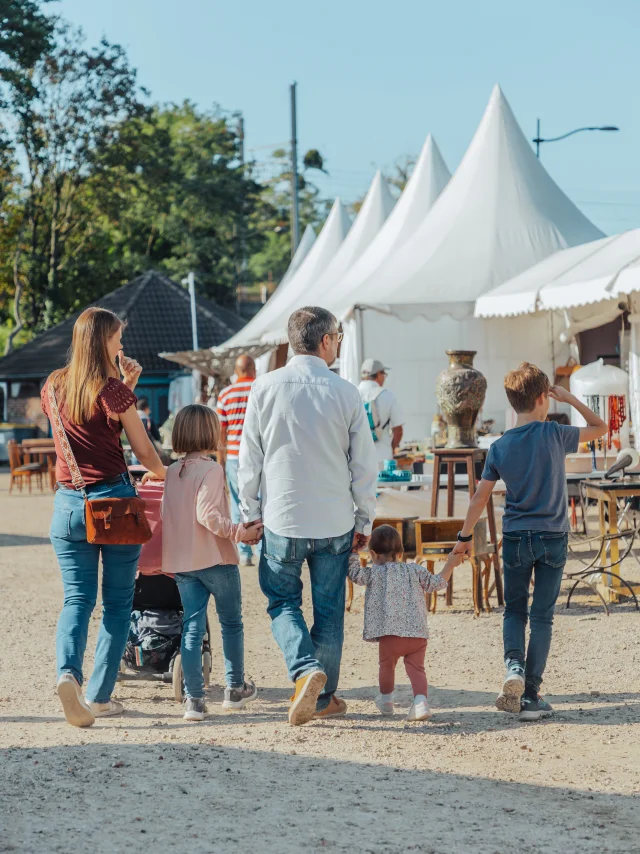 Famille avec les deux parents et les trois enfants marchant de dos à la foire de Chatou