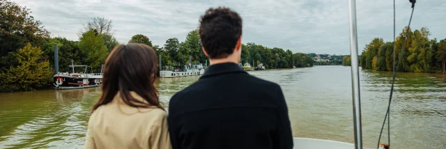 Couple entrain de regarder la seine pendant une croisière