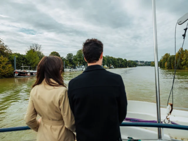 Couple entrain de regarder la seine pendant une croisière