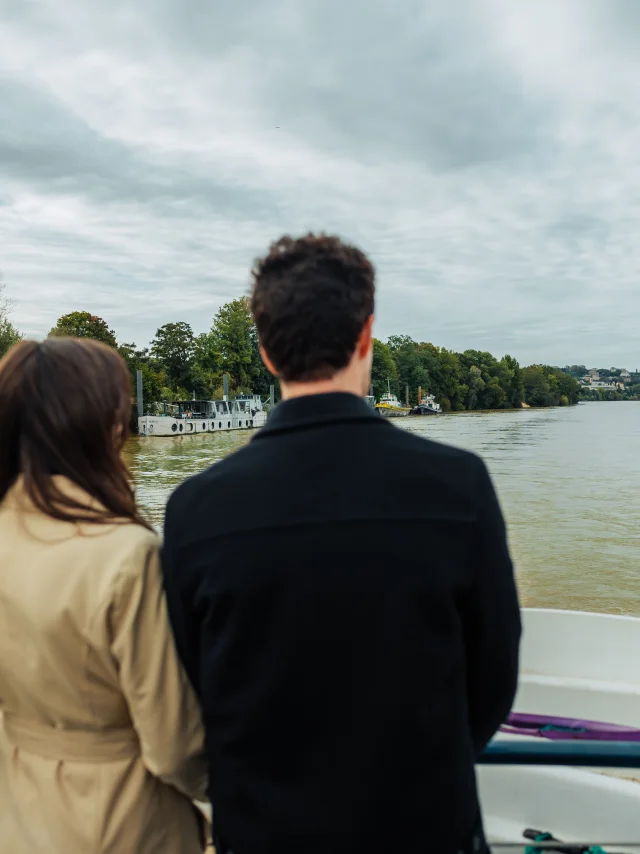 Couple entrain de regarder la seine pendant une croisière