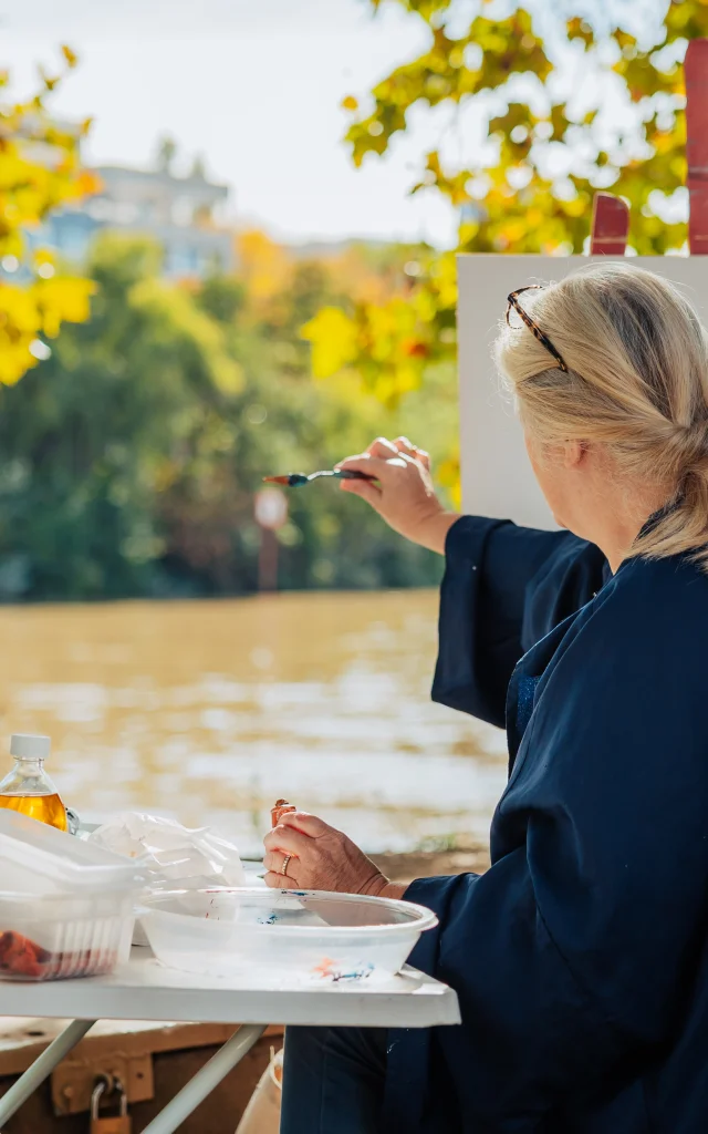 Woman painting on a canvas on the banks of the Seine