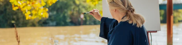 Femme entrain de peindre sur une toile en bords de Seine