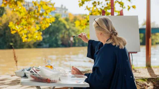 Femme entrain de peindre sur une toile en bords de Seine