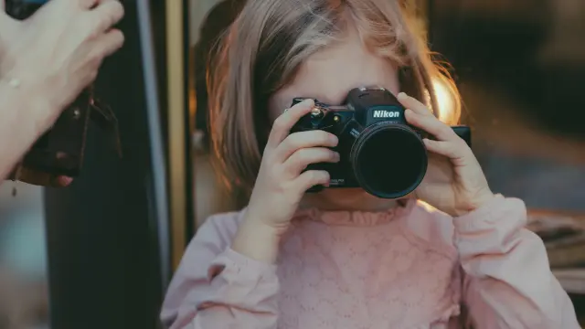 Une petite fille s'amusant avec un appareil photo pendant la foire de Chatou - OTISGBS