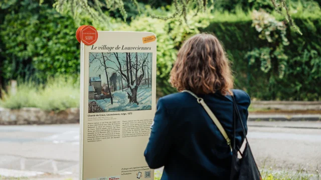 Personne regardant un panneau du Chemin des Impressionnistes à Louveciennes