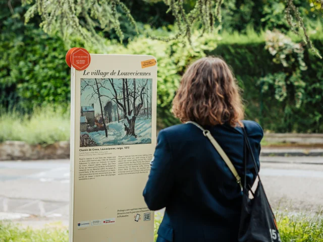 Personne regardant un panneau du Chemin des Impressionnistes à Louveciennes