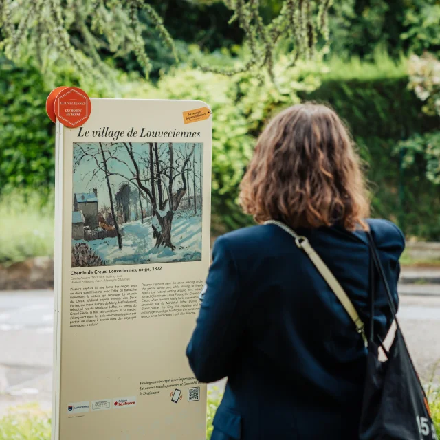 Personne regardant un panneau du Chemin des Impressionnistes à Louveciennes