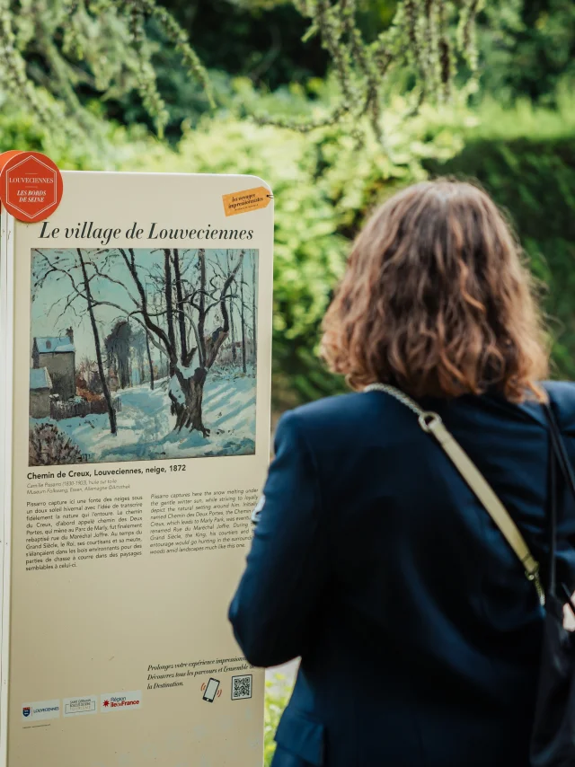 Personne regardant un panneau du Chemin des Impressionnistes à Louveciennes