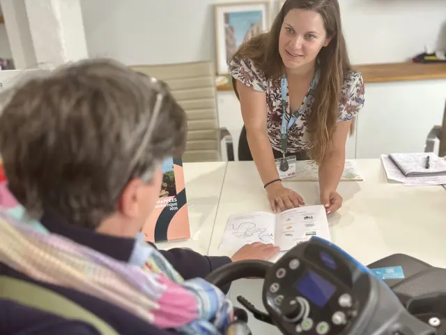 Personne en fauteuil roulant à l'accueil de l'office de tourisme SGSB