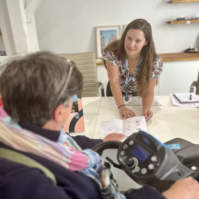 Personne en fauteuil roulant à l'accueil de l'office de tourisme SGSB
