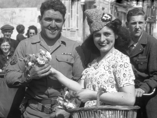 Une femme accueille un soldat américain avec des fleurs au Pouliguen, lors de la libération de la poche de Saint-Nazaire, le 11 mai 1945.
