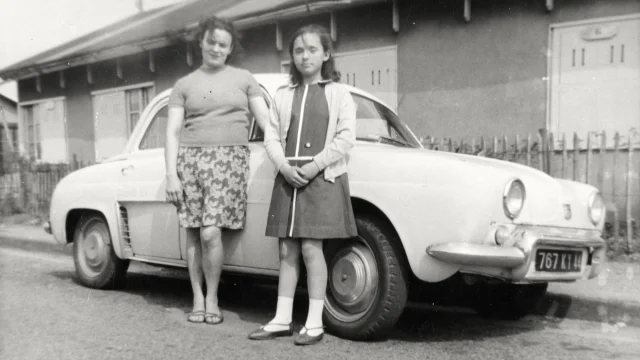 Une Femme Et Une Enfant Posent Appuyees A Une Renault Dauphine Devant Un Baraquement De Cite Provisoire Dans Les Annees 1950 Collection Lanuel Ecomusee