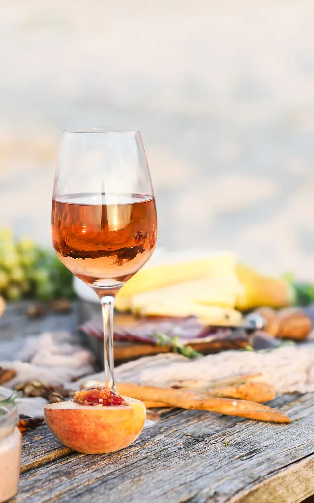 Glass of rose wine on rustic table. Food and drink background