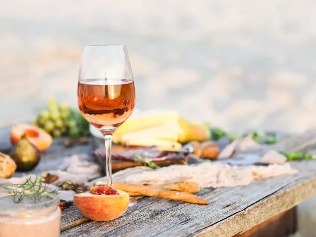 Glass of rose wine on rustic table. Food and drink background