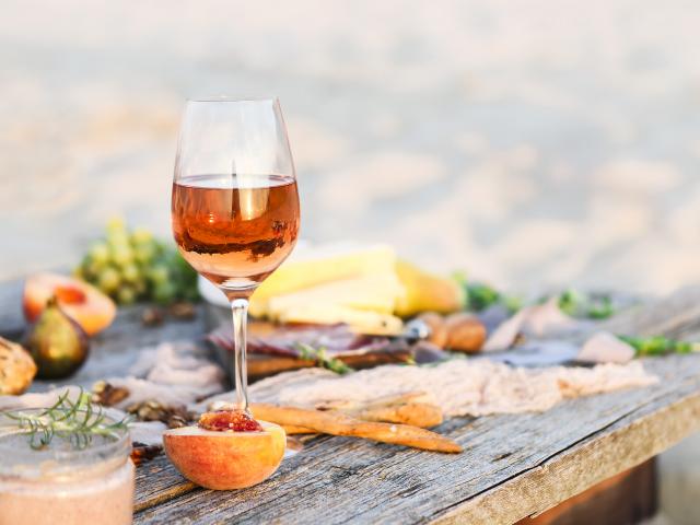 Glass of rose wine on rustic table. Food and drink background