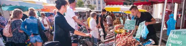 clients à vélo achetant leurs fruits et légumes au marché de Louviers en Normandie
