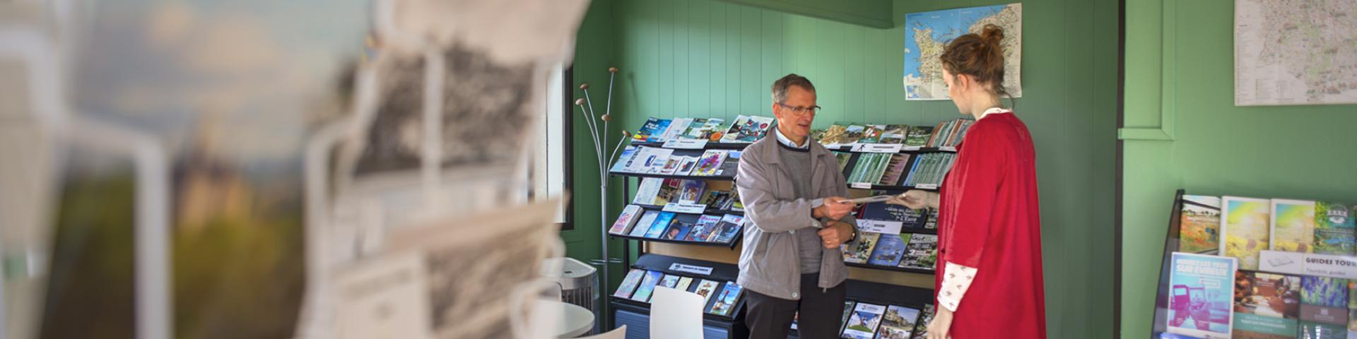 Gaillon tourist office advisor presenting a document to a tourist.