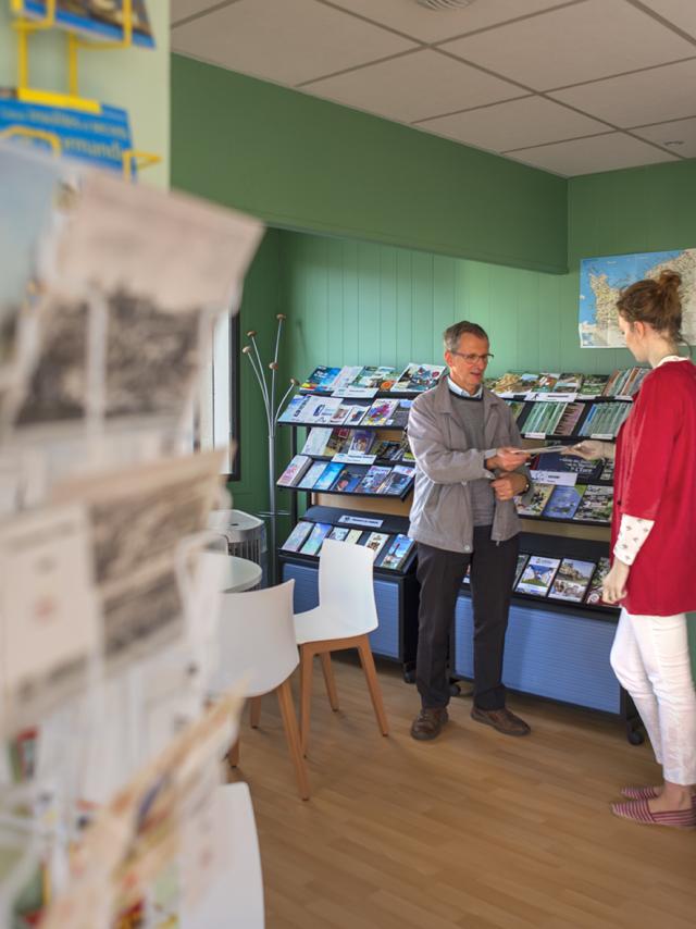 Conseillère de l'office de tourisme de Gaillon en train de renseigner un touriste en lui présentant un document