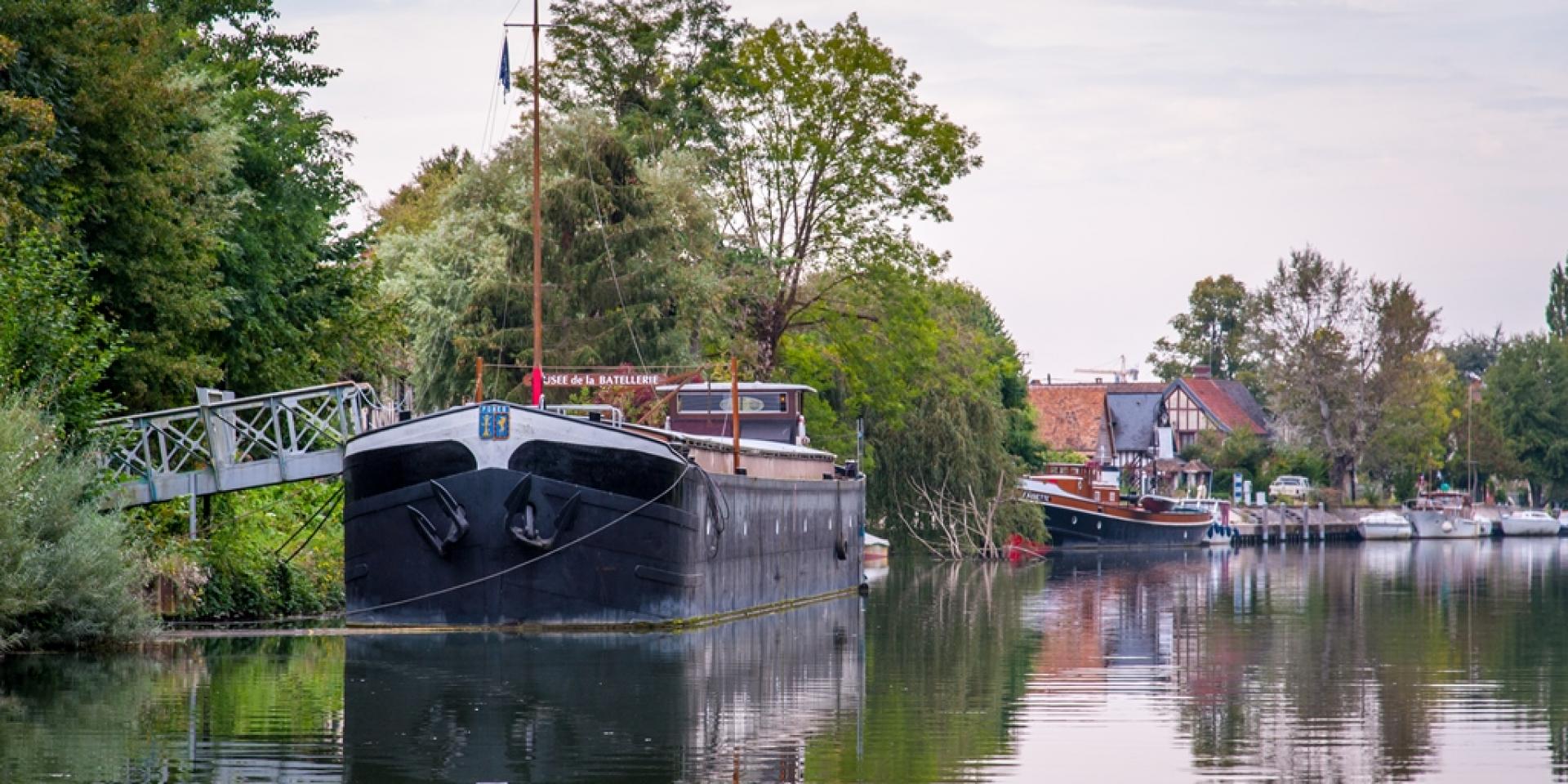 photo des bords de seine en campagne normandes avec ses anciens bateaux amarrés