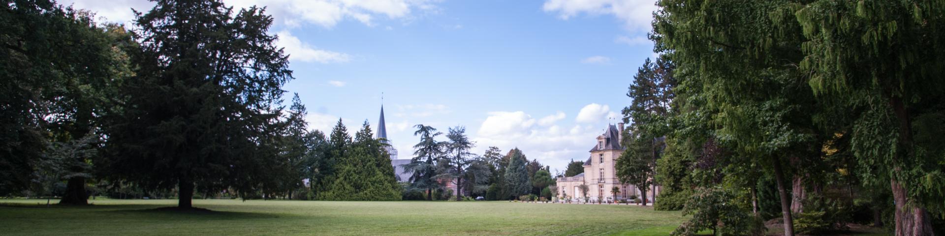 photo d'un banc blanc et vert dans le grand jardin du parc ensoleillé du château d'Acquigny dans l'Eure en Normandie