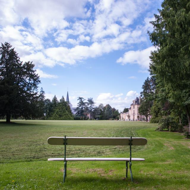 photo of a white and green bench in the large garden of the sunny park at Château d'Acquigny in Eure, Normandy