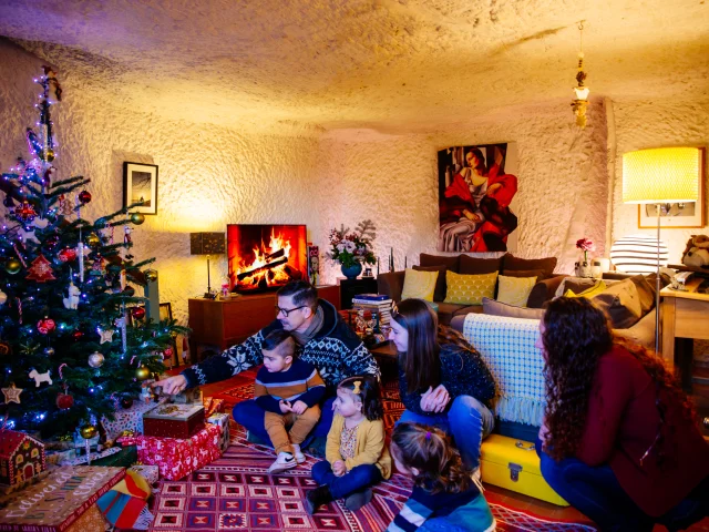 Famille devant un sapin de noël dans un salon d'une maison troglodytique