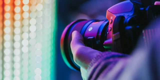 Un appareil photo tenu dans une main devant une lumière