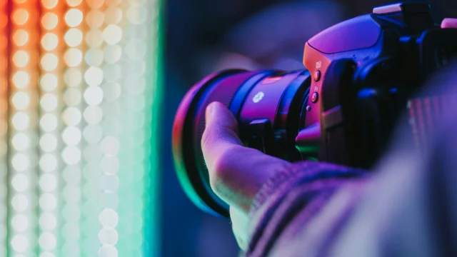 Un appareil photo tenu dans une main devant une lumière