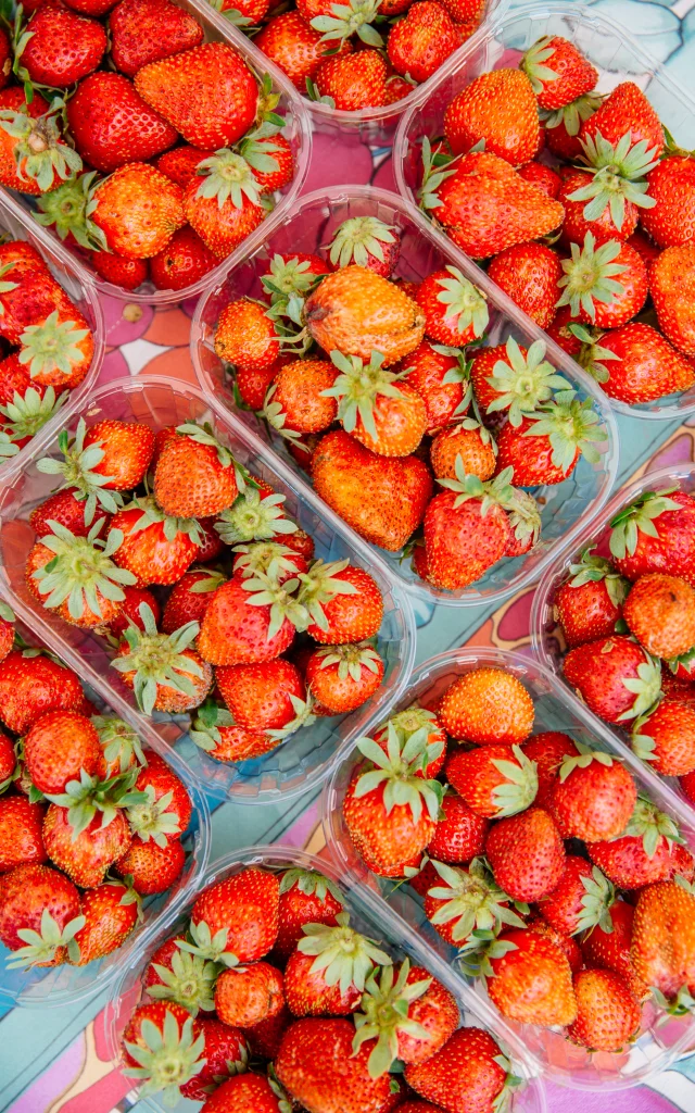 Prise de vue du haut de plusieurs barquettes de fraises rouges vives.