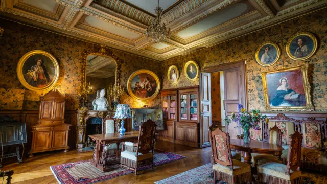 Salon historique du Château de Montrésor avec mobilier d’époque, portraits anciens, boiseries et plafond richement décoré.