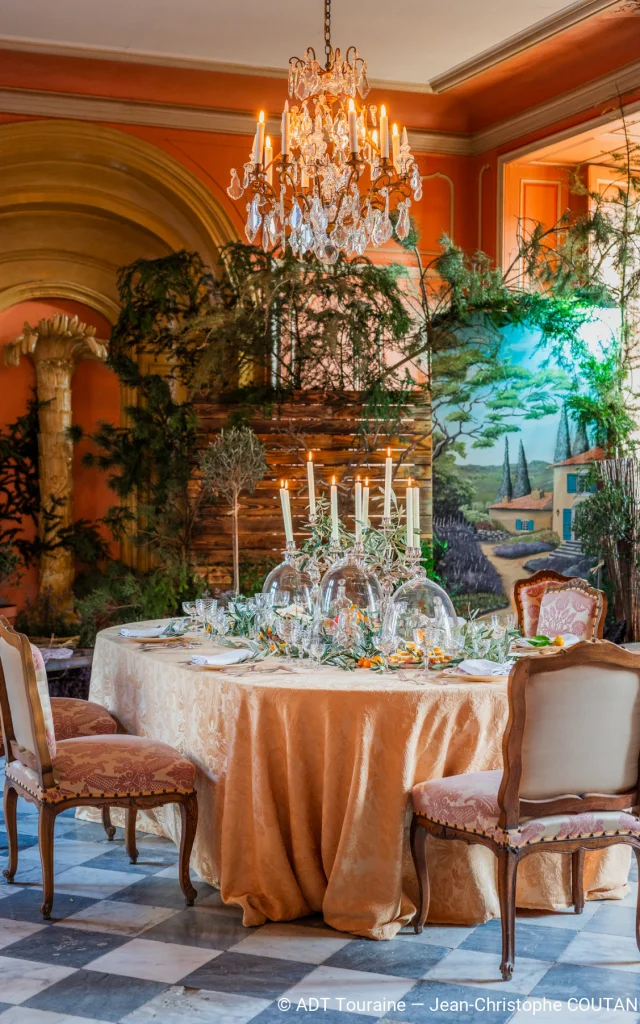 Table décorée pour Noël au château de Villandry, avec chandeliers, vaisselle raffinée et décor végétal.