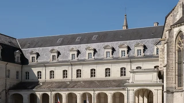 Façade principale de l’Abbaye de Pontlevoy, monument historique en pierre de tuffeau, sous un ciel bleu.