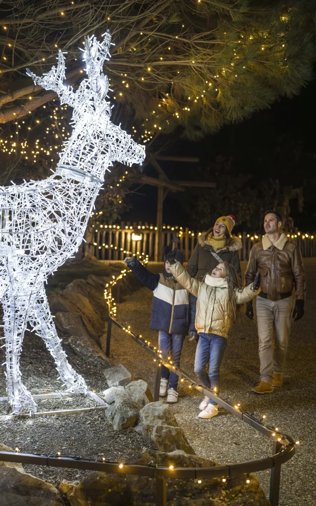 Une famille heureuse au ZooParc de Noel profitant de la magie des illuminations
