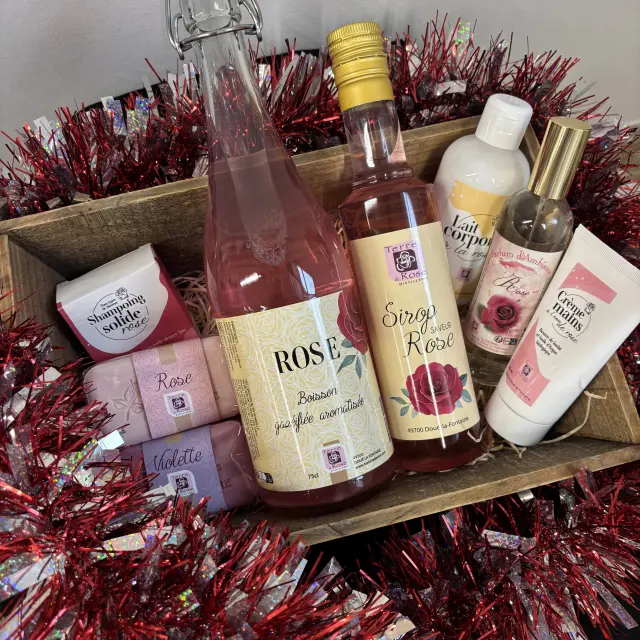 Panier de produits parfumés à la rose incluant boisson, sirop, savons, shampooing solide, lotion corporelle, parfum d’ambiance et crème pour les mains.