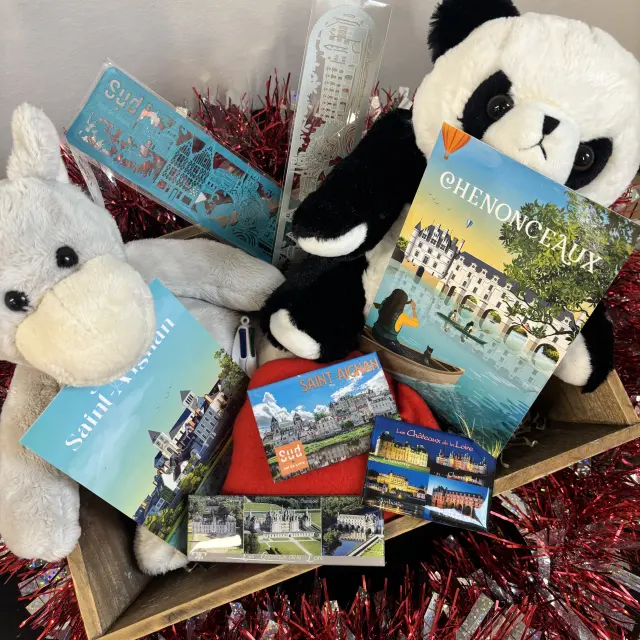 Panier de souvenirs touristiques incluant peluches, cartes postales, magnets et marque-pages illustrés des sites du Sud Val de Loire.