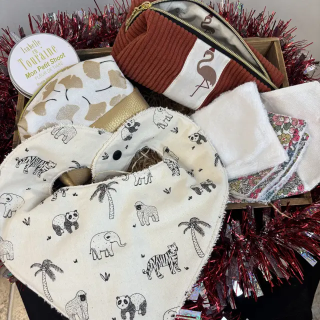 Panier regroupant des créations textiles : bavoir, lingettes lavables et trousse en tissu.