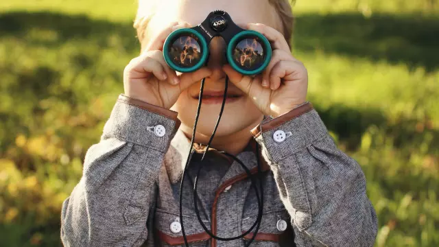 Enfant gros plan paire de jumelles Terres d'Oiseaux