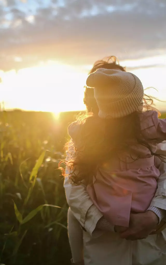 Enfant sur le dos de sa mère contrejour