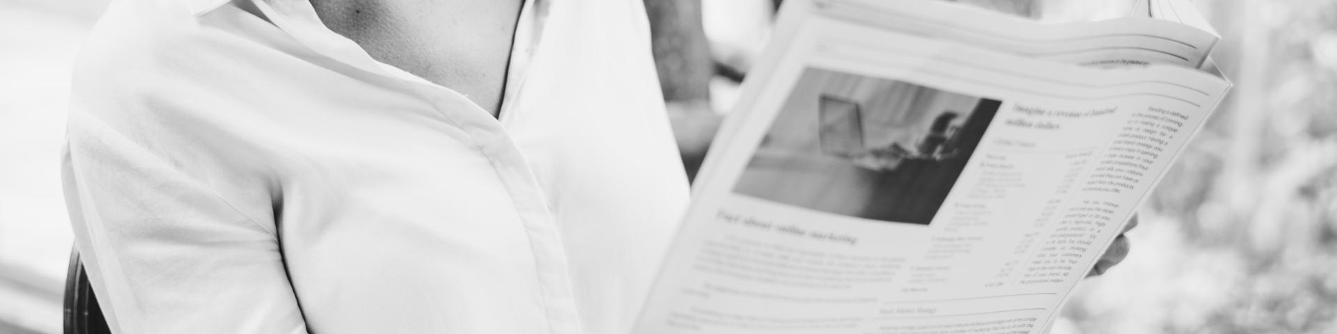 Business woman reading newspaper in the morning