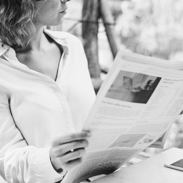Business woman reading newspaper in the morning