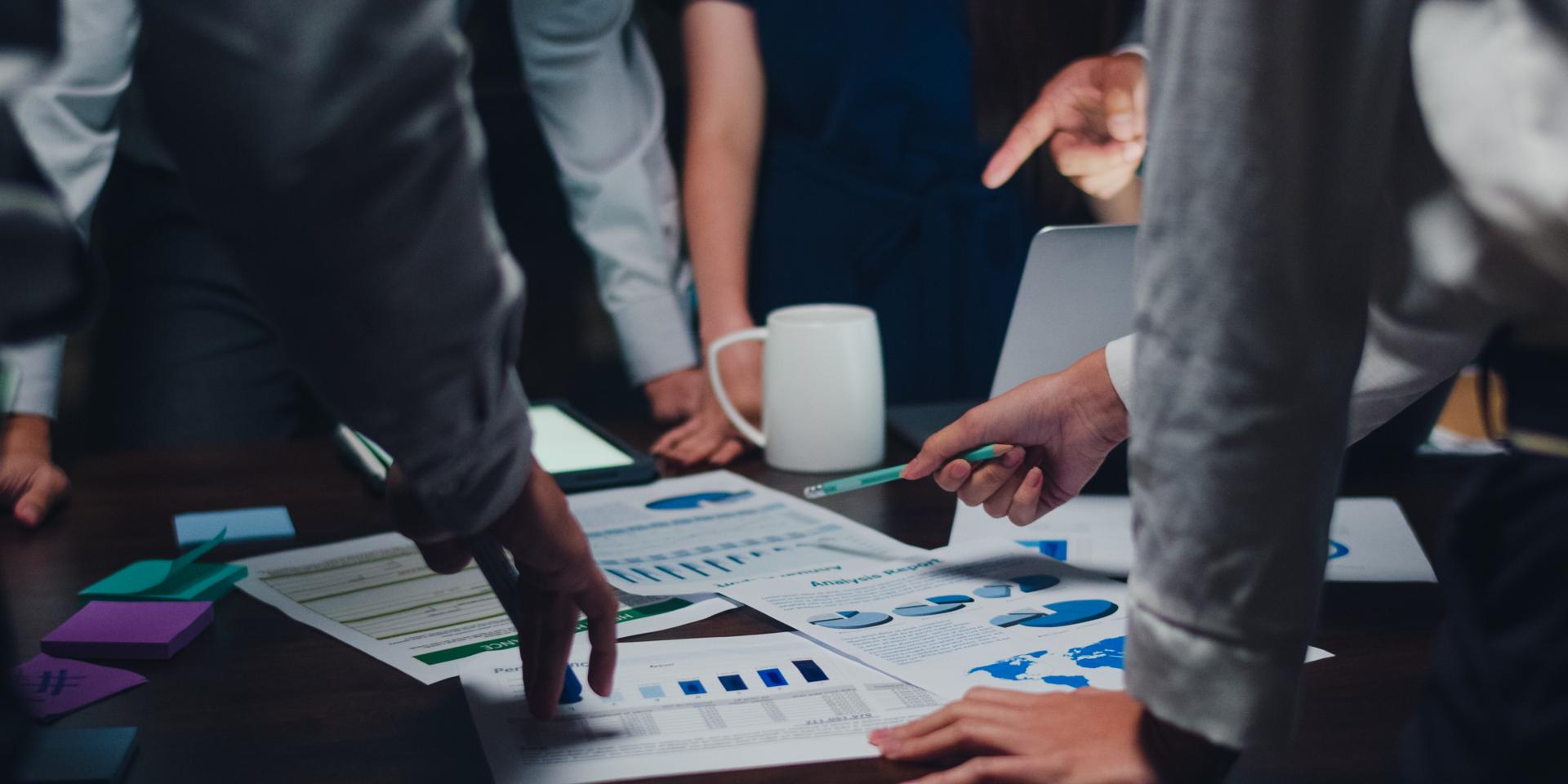 Millennial Asia businessmen and businesswomen meeting brainstorming ideas about new paperwork project colleagues working together planning success strategy enjoy teamwork in small modern night office.