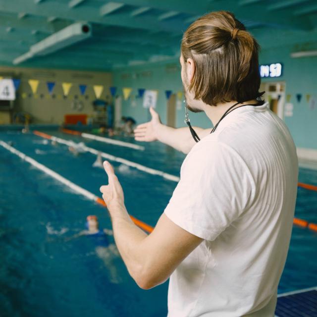 Entraineur Natation Masculin Debout Au Bord Piscine Il Montre Main Droite Pour Corriger Etudiant Technique Natation Professionnel