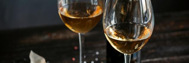 dinner concept for two. two glasses of white wine, baked fish.