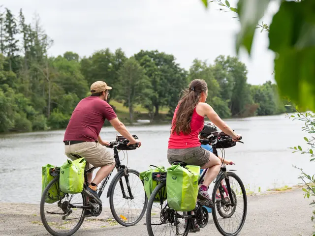 Un couple à vélo longe la rivière La Mayenne par le chemin de halage