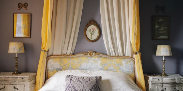 Chambres d'Hôte La Maison d'Hercule. Une jolie chambre décorée dans les tons de jaune avec un ciel de lit à l'ancienne