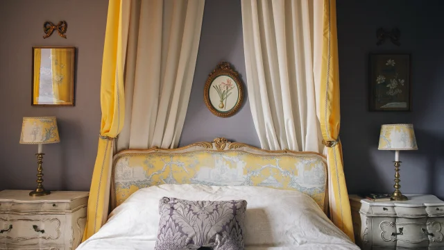 Chambres d'Hôte La Maison d'Hercule. Une jolie chambre décorée dans les tons de jaune avec un ciel de lit à l'ancienne