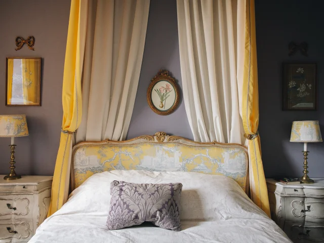 Chambres d'Hôte La Maison d'Hercule. Une jolie chambre décorée dans les tons de jaune avec un ciel de lit à l'ancienne