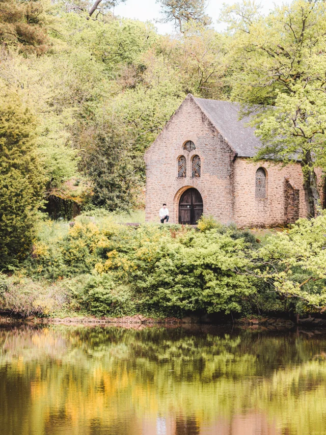 A Fontaine Daniel un homme se tient devant la chapelle près de l'étang.