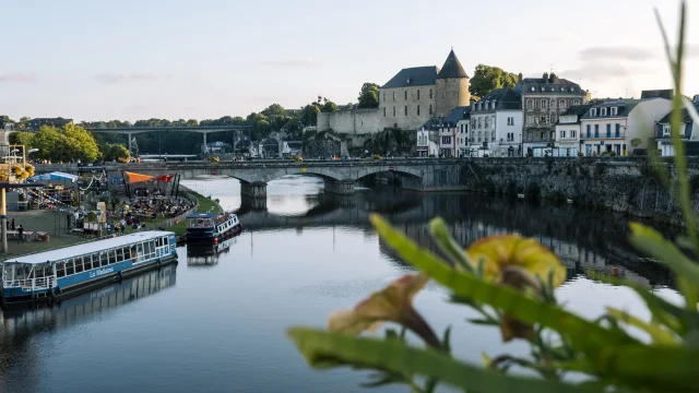 La ville de Mayenne, douce lumière de fin de journée. Vue sur le château, la rivière et le bateau La Meduana.
